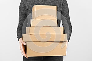 A stack of cardboard boxes in the hands of a people on a white background. Free shipping, return of parcels