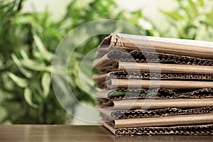 Stack of cardboard for recycling on table against blurred background.