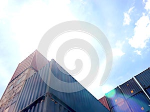 Stack of cargo container box at noon in logistic shipping yard whit blue sky on sunny day