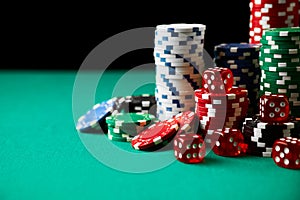 Stack of Casino gambling chips and dices on green table
