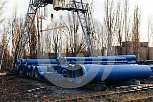 Stack of cast iron pipes in loading area waiting for transportation