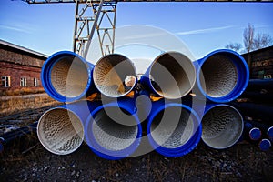 Stack of cast iron pipes in loading area waiting for transportation