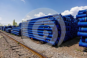Stack of cast iron pipes in loading area waiting for transportation