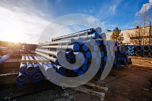 Stack of cast iron pipes in loading area waiting for transportation
