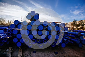 Stack of cast iron pipes in loading area waiting for transportation