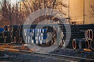 Stack of cast iron pipes in loading area waiting for transportation