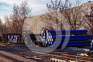 Stack of cast iron pipes in loading area waiting for transportation