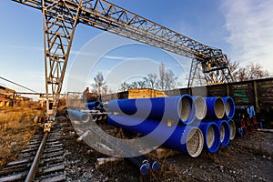 Stack of cast iron pipes in loading area waiting for transportation