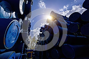 Stack of cast iron pipes in loading area waiting for transportation
