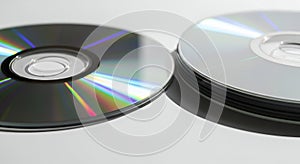 Stack of CDs and a single CD with rainbow reflections
