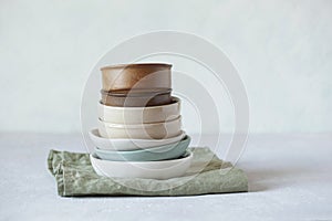 Stack of ceramic bowls of beige colos on the green cotton napkin photo