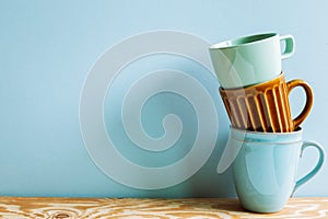 Stack of ceramic mug cups on wooden table
