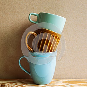 Stack of ceramic mug cups on wooden table
