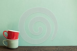 Stack of ceramic mug cups on wooden table