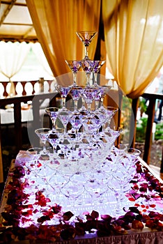 Stack of champagne glasses on table in wedding party.
