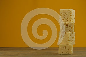 Stack cheese cubes on a wood kitchen table