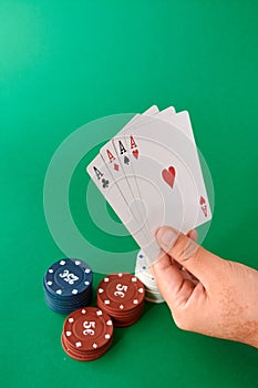 Stack of chips and hand with four aces Poker cloth a deck of cards poker hand and chips. Background