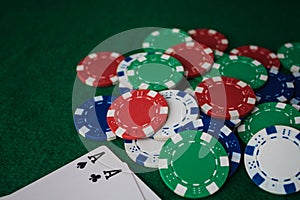 Stack of chips poker and two aces on the table on the green baize. Perspective view