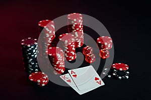 Stack of chips and two cards on dark background - poker game concept