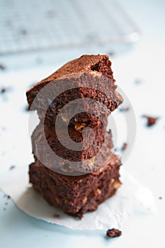 Stack of chocolate brownies on pastel blue background