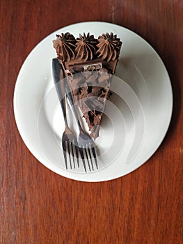 A stack of chocolate brownies serve on a round white plate. A