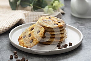 Stack of chocolate chip cookies. Dark background. Sweet delicious snack.