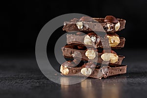 Stack of chocolate slices with mint leaf.Hazelnut and almond milk and dark chocolate pieces tower.Sweet food photo concept. The