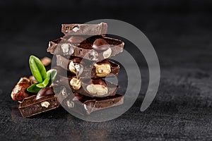 Stack of chocolate slices with mint leaf.Hazelnut and almond milk and dark chocolate pieces tower.Sweet food photo concept. The