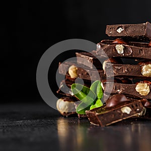 Stack of chocolate slices with mint leaf.Hazelnut and almond milk and dark chocolate pieces tower.Sweet food photo concept. The