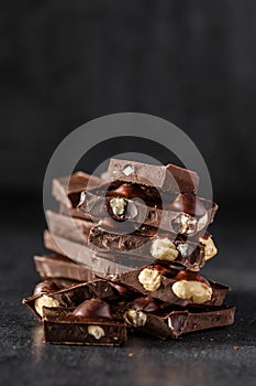 Stack of chocolate slices with mint leaf.Hazelnut and almond milk and dark chocolate pieces tower.Sweet food photo concept. The