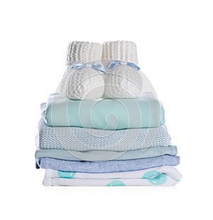 Stack of clean baby`s clothes and small booties on white background