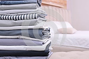 Stack of clean bed linens in bedroom. Space for text