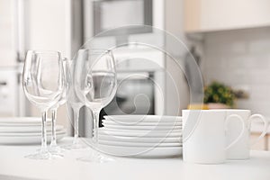 Stack of clean dishes, glasses and cups on table