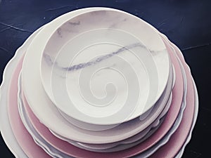 Stack of clean empty plates on black background, dishware and table decor