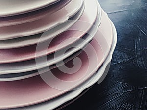 Stack of clean empty plates on black background, dishware and table decor