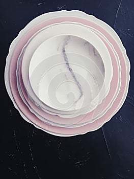 Stack of clean empty plates on black background, dishware and table decor