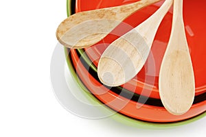 stack of clean empty plates and wooden spoons