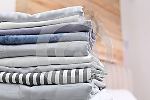 Stack of clean linens in bedroom, closeup