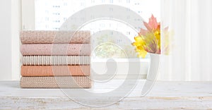 Stack of clean neatly folded women clothes on wooden table photo