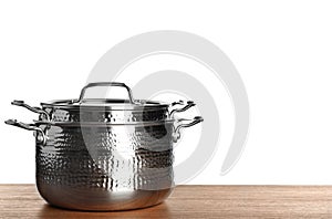 Stack of clean saucepans on table against white background photo