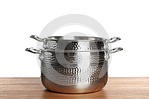 Stack of clean saucepans on table photo