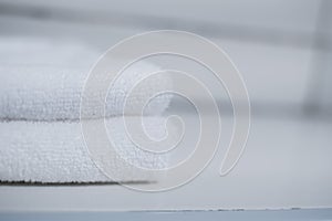 Stack of clean soft white towels on table against light grey background photo