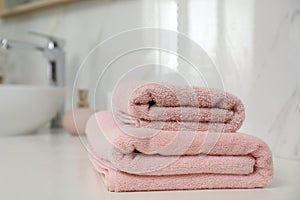 Stack of clean towels on bathroom countertop