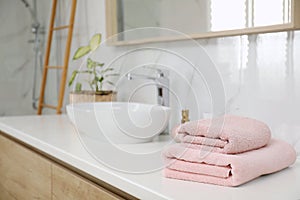 Stack of clean towels on bathroom countertop