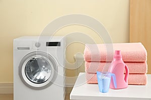 Stack of clean towels and detergents on table in laundry room