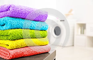 Stack of clean towels on table in laundry room