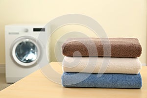 Stack of clean towels on table in laundry room