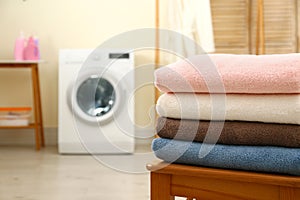 Stack of clean towels on table in laundry room