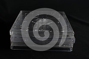 Stack of clear retro CD cases with no Compact Discs against a black background
