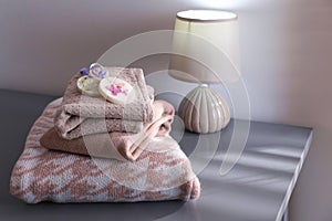 Stack of clothes with beautiful scented wax sachets on grey table indoors